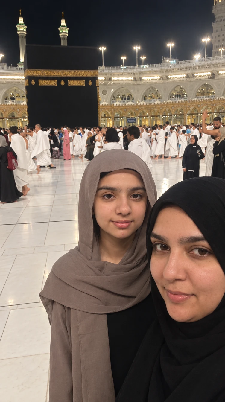 Arwa and a family member in hijabs at the Haram in Makkah at night, the Kaaba and pilgrims behind them.